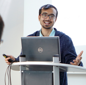 A man standing in front of a monitor 