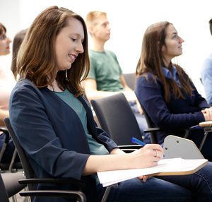 A women taking notes at a conference 