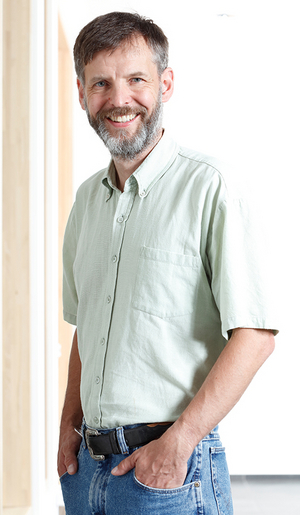 Peter Baumann, Adjunct Director at the Institute of Molecular Biology (IMB), standing in front of a window.